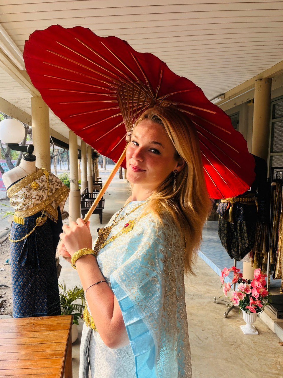 Teacher in traditional Thai dress with red umbrella